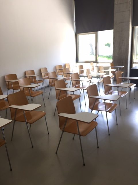 Einzelstühle im Seminarraum mit jeweils einem kleinen Tisch am Stuhl