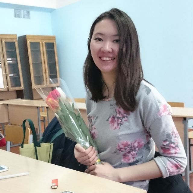 Kasachische Studentin mit Tulpen in der Hand.