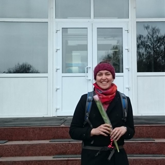Theresa mit einer Tulpe in der Hand vor dem Gebäude der Almatiner Technischen Universität.