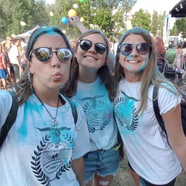 Ich mit meinen zwei besten Freundinnen auf dem holi festival, mit breitem grinsen und viel blauer Farbe