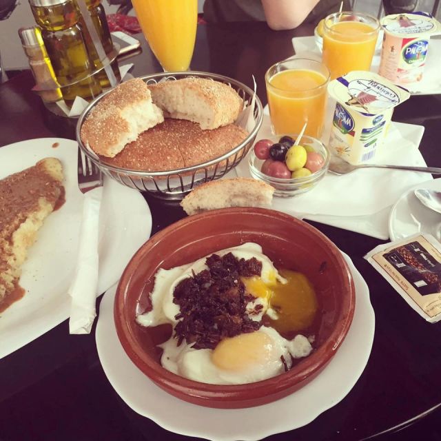 Das Frühstück in einem kleinen Café in Tangier. Auf dem Bild ist ein marokkanischen Frühstück mit Spiegeleiern, Orangensaft und Brot, etc. zu sehen.
