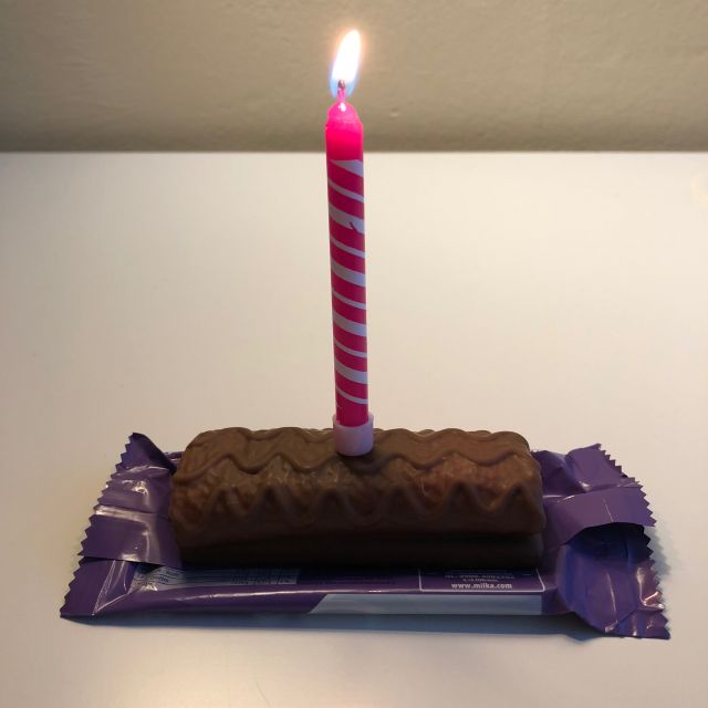 Schokoriegel mit Kerze als Ersatz für den Geburtstagskuchen