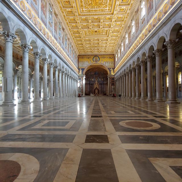 Das menschenleere Innere der Kirche. Vergoldete Decke, Marmorboden und viele Säulen.