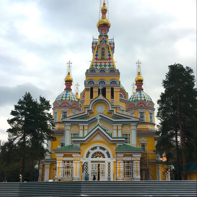 Die gelbe russisch-orthodoxe Kirche in Almaty umgeben von einem Bauzaun