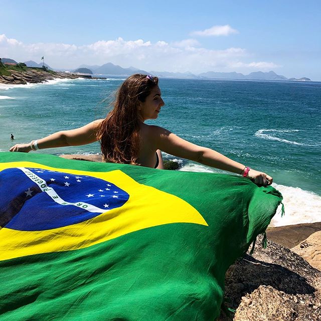 Mädchen mit brasilianischer Flagge vor dem Meer