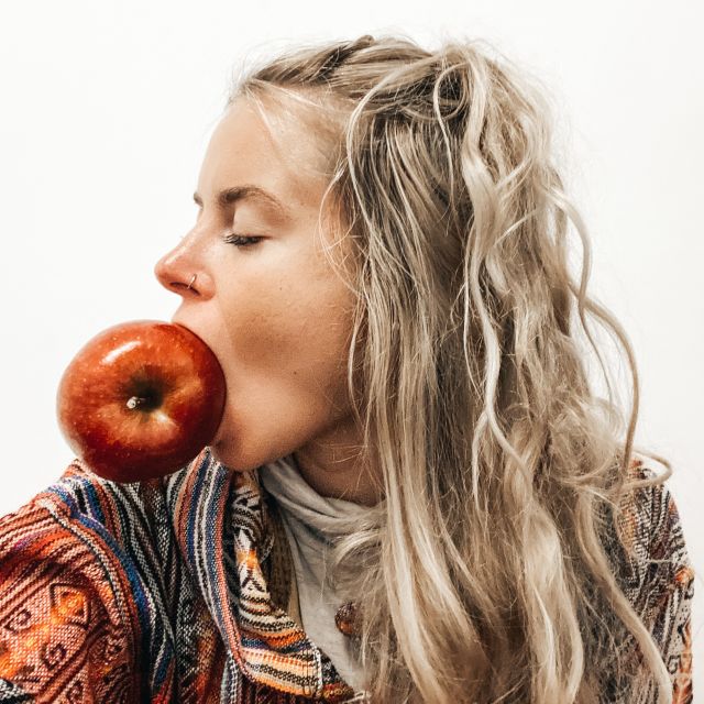 Frau beißt in einen Apfel.