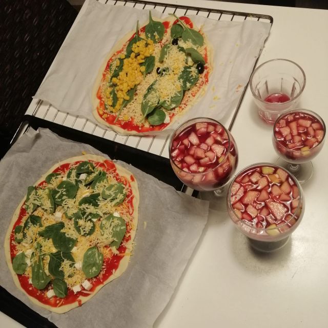 53861ef9-e45f-4eb5-835f-bb2d4c86743e Zwei selbstgemachte Pizzen und drei Gläser, die gefüllt sind mit Sangria