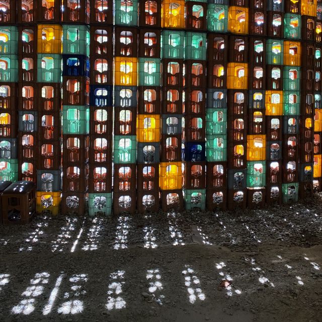 Sonnenlicht scheint durch die Zwischenräume des Kunstwerks 'Anyang Crate House - dedicated to the lost' von dem deutschen Künstlern-Duo Wolfgang Winter und Berthold Hörbelt