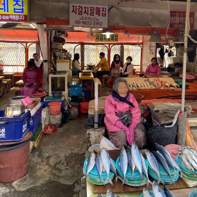 Ältere Frau sitzt an ihrem Stand auf dem Jalgachi Fischmarkt