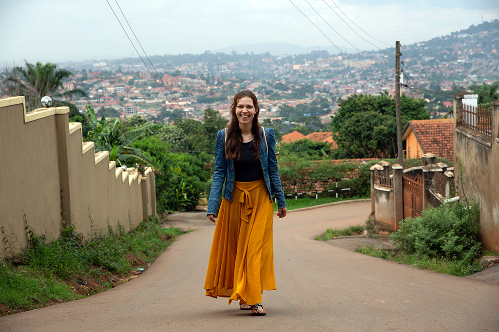 Lara läuft eine Straße in Uganda hinauf.