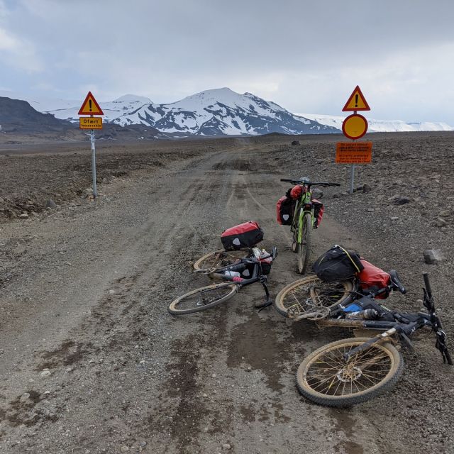 Dreckige Fahrräder und Schilder vor einer geschlossenen Highland Straße in Island.