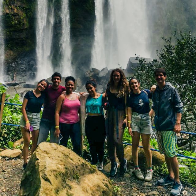 Sieben junge Leute aus verschiedensten Teilen der Welt stehen vor einem Wasserfall.