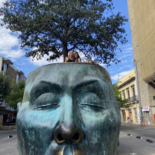 Skulptur eines großen Kopfes, aus dem ein Baum wächst.