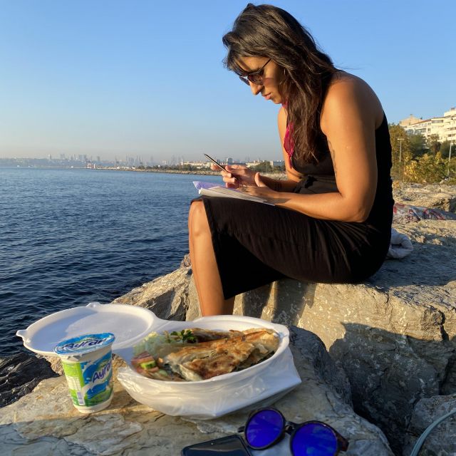 Sophies Freundin Albertina sitzt abends am Meer, Essen und Onlineuni sind auch mit dabei.
