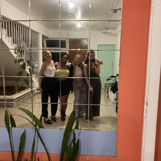 Carla und 3 Freundinnen stehen in Partyoutfits vor einem großen Wandspiegel.