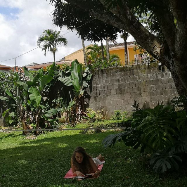 Carla liegt im Garten auf einer Yogamatte.