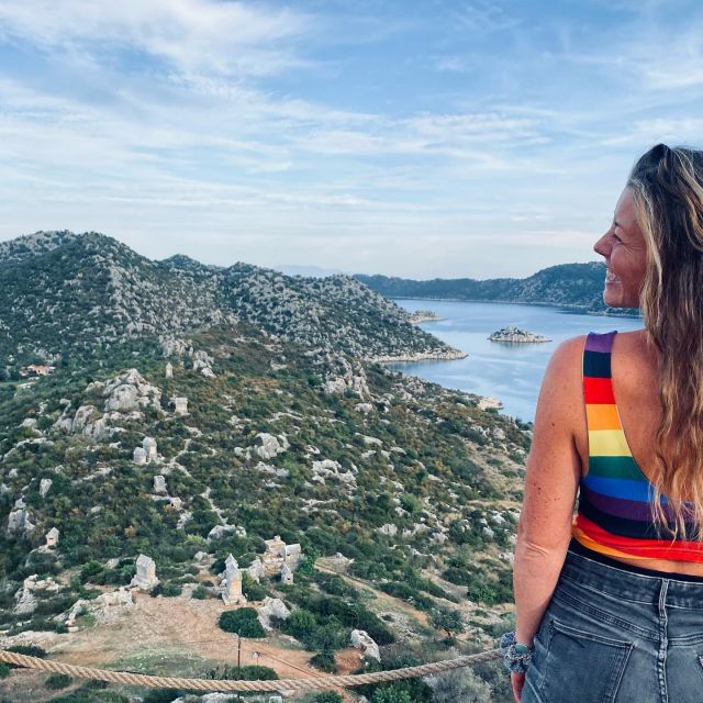 Sophie auf einer Insel vor Kaş. Im Hintergrund sind Berge und Meer zu sehen.