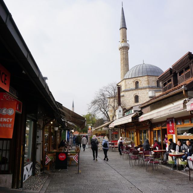 Straße mit Geschäften links und rechts. Moschee rechts im Bild.