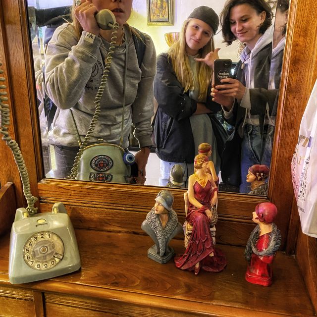 Sophie, Agnieszka und Hania albern vor dem Spiegel eines Restaurants rum. Sophie telefoniert mit einem alten Telefon samt Wählscheibe.