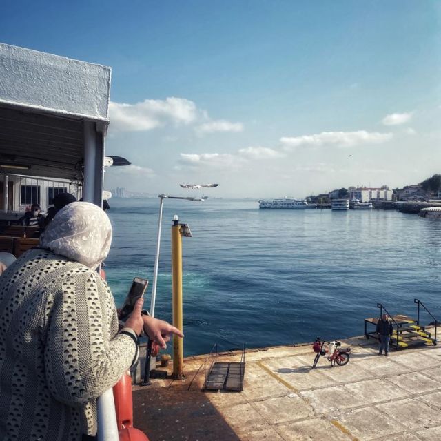 Eine Frau mit Kopftuch steht auf der Fähre, die gerade auf der Insel Büyük Ada ankommt.