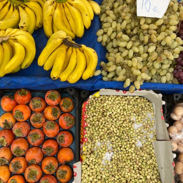 Kaki, Bananen und Gewürze auf dem Markt.