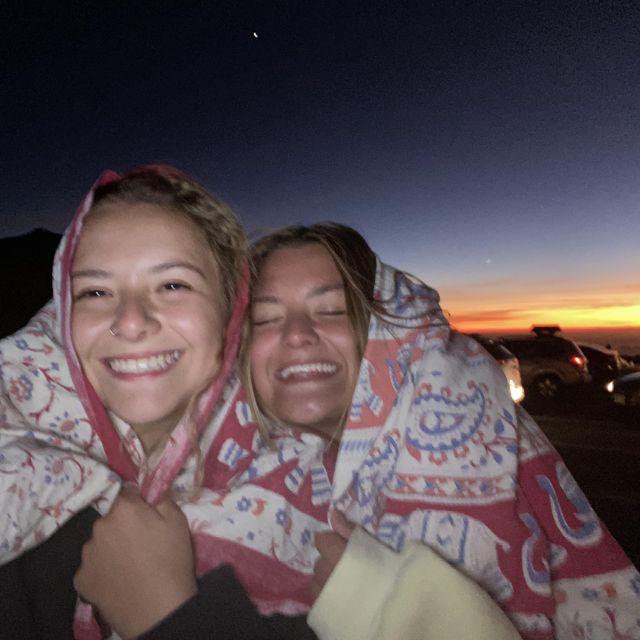 Julia und Victoria mit Decke auf dem Kopf und im Hintergrund Sonnenuntergang