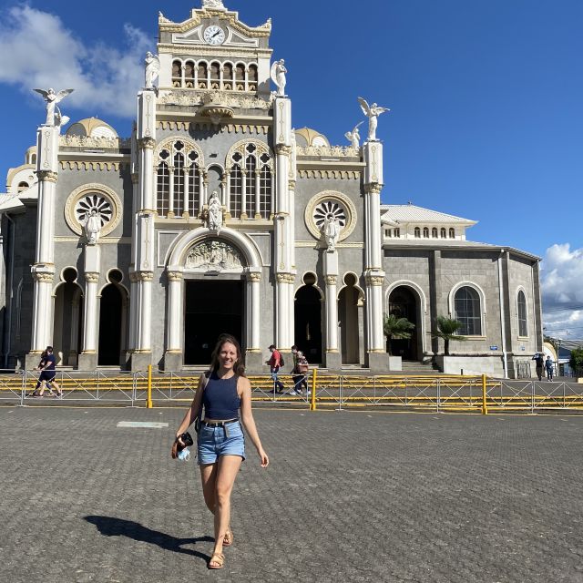 Carla steht bei strahlendem Sonnenschein vor einer Kirche im Kolonialstil