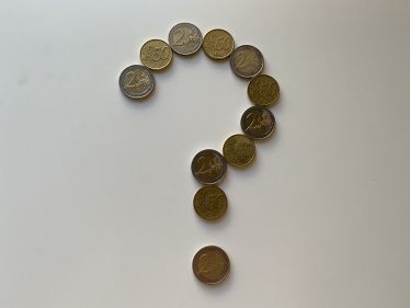 Münzen formen ein Fragezeichen