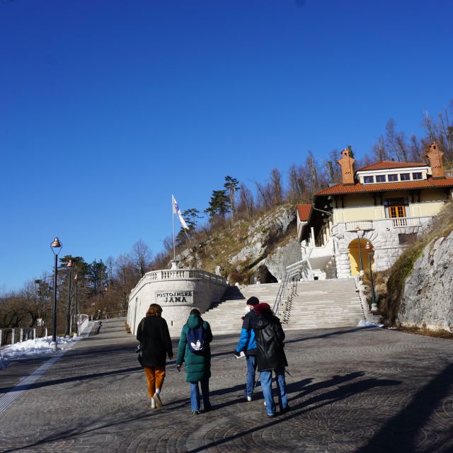 Gruppe von Mneschen geht auf eine weiße Steintreppe zu.