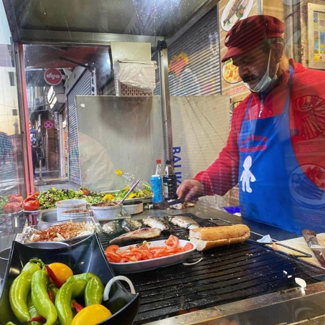 Mario steht hinter dem Grill seines kleinen Lokals in Karaköy und brät Fisch, balık.