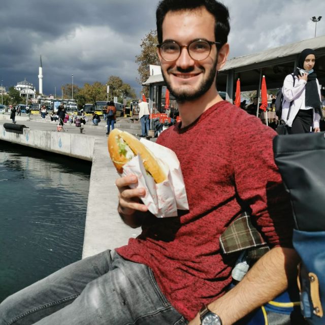 Yasin posiert mit einem Fischbrötchen, balık ekmek, am Hafen von Kadiköy,