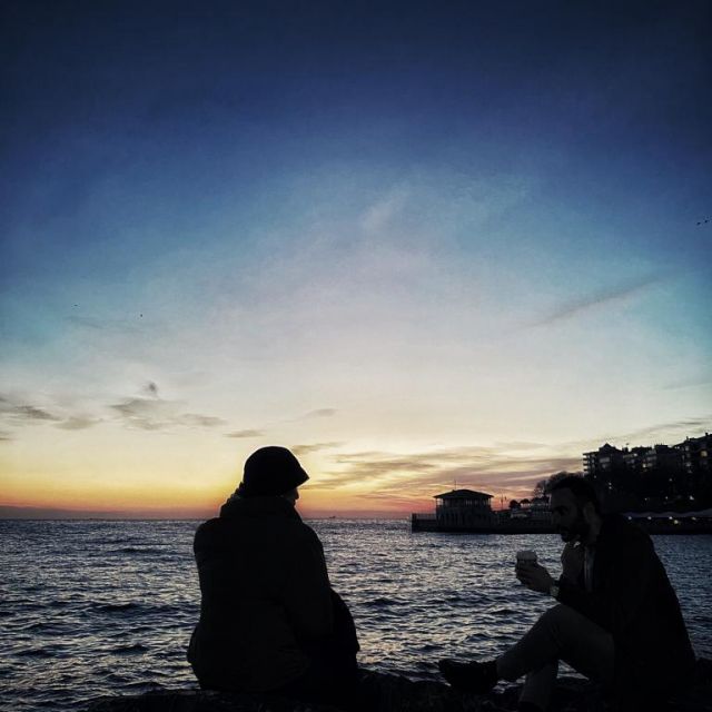 Sonnenuntergang. Die Silhouette eines Paares ist zu erkennen.