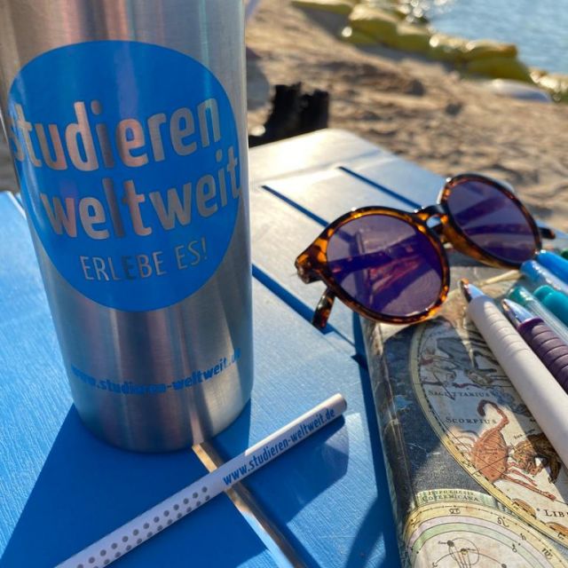 Sophies Tasse, Notizbuch, Stifte und Sonnenbrille am Strand von Heybeliada.