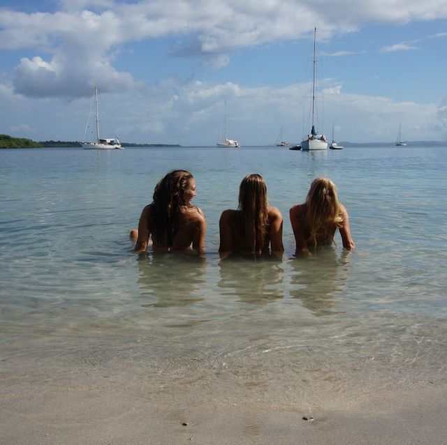 Carla und zwei Freundinnen liegen im flachen Wasser am Strand.