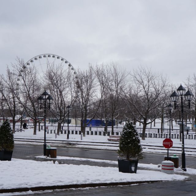 Altstadt von Montreal ist in Schnee gehüllt. Im Hintergrund steht ein Riesenrad.