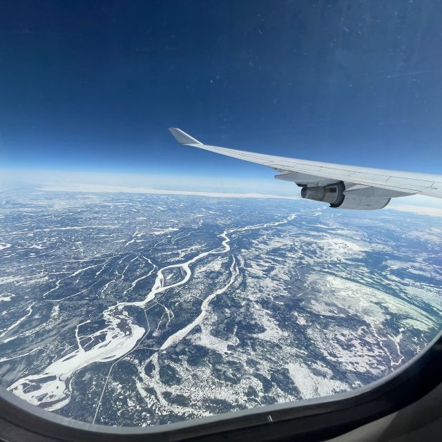 Blick auf Tundra und Flugzeugflügel aus dem Fenster eines Flugzeugs