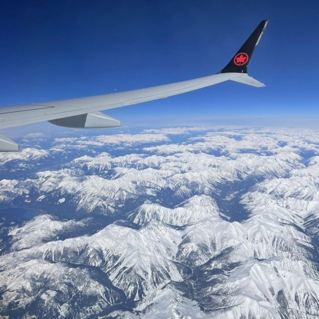 Blick aus dem Flugzeugfenster auf die Rockie Mountains, diese sind mit Schnee bedeckt