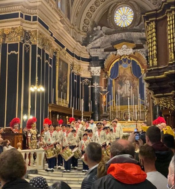 Eine Gruppe junger Musiker steht mit Trommeln in einer gefüllten Kirche vor dem Altarraum.