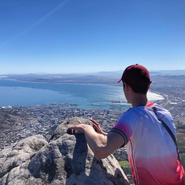 Aufnahme von hinten von Erik während er vom Gipfel des Tafelbergs auf Kapstadt schaut