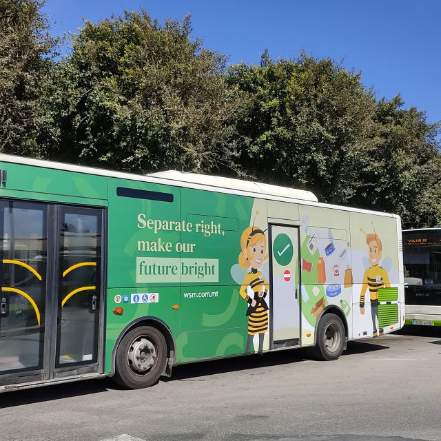 Ein Bus mit grüner Werbung steht auf der Straße