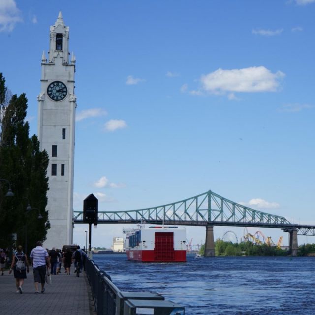 Der Hafen von Montreal. Ein alter Glockenturm links vor einer großen Brücke.