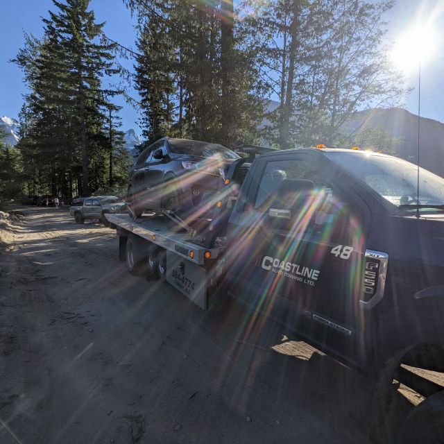 Das Auto auf dem Abschleppwagen von hinten von der Sonne beleuchtet