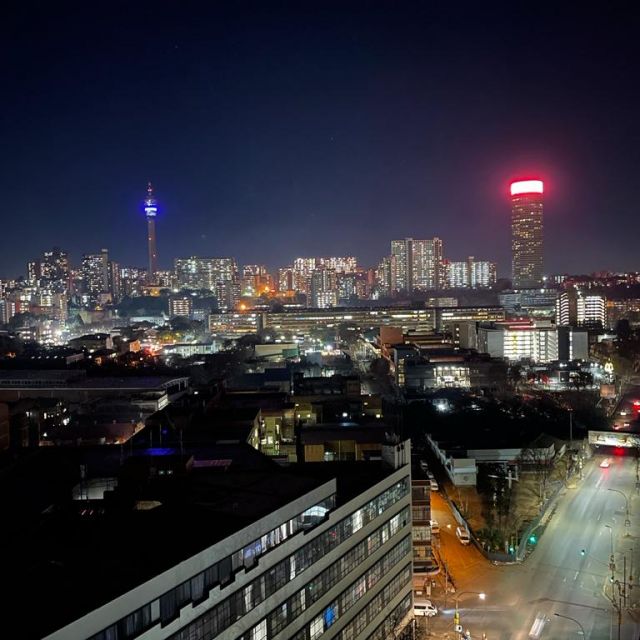 Foto der beleuchteten Skyline von Johannesburg bei Nacht.