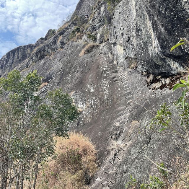 Ein steiler Felsen mit Steigbügeln zum Klettern