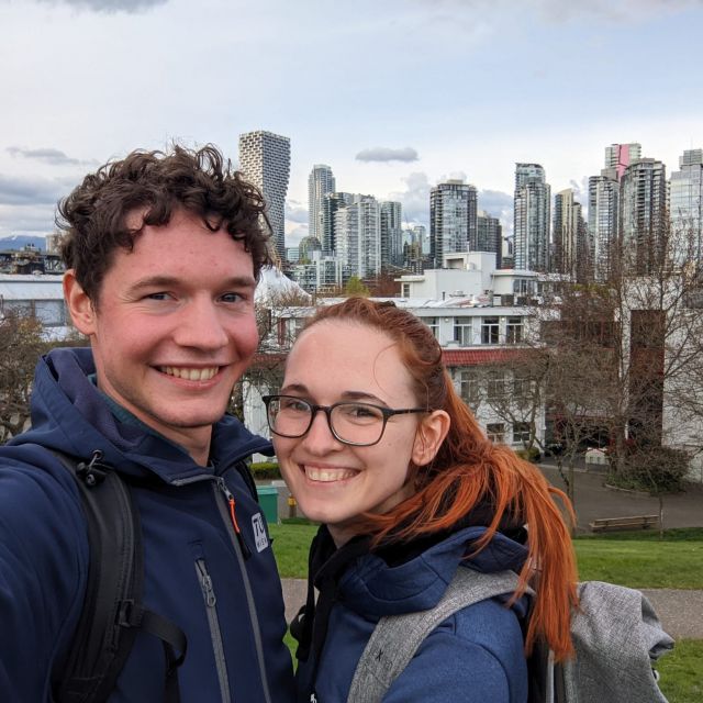 Ronja und Lukas auf einem Hügel vor der Skyline von Vancouver.