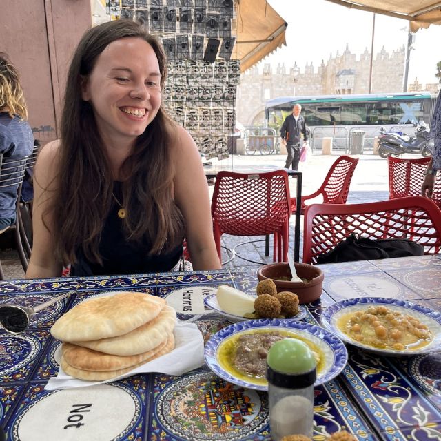 Sarah sitzt am Tisch mit Hummus, Falafel und Fladenbrot