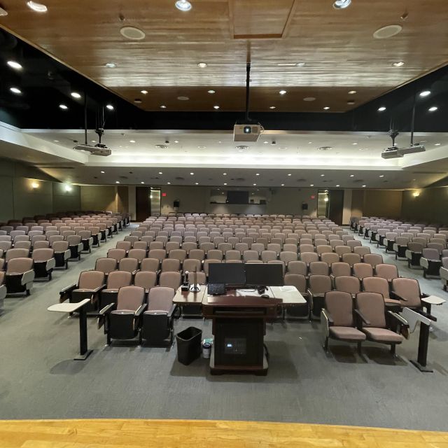 Das Bild zeigt einen großen Hörsaal hier an der TAMU aus Sicht eines Dozenten. Diese stehen vorne auf einem Podium und sprechen zu den Studenten.