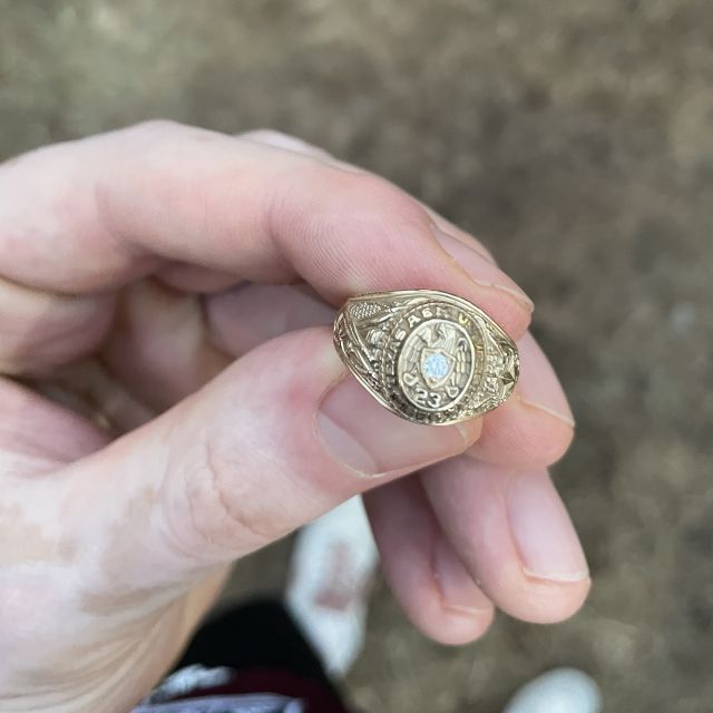 Hierbei handelt es sich um einen kleineren goldenen Aggie Ring mit Edelstein in der Mitte.