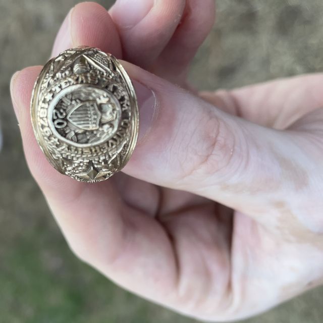 Zusehen ist ein goldener Aggie-Ring, wie Ihn die Männer tragen. Der geschriebene Text beschreibt diesen Ring.