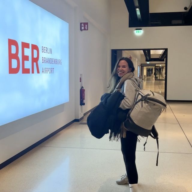 Sarah mit Rucksack am Flughafen.